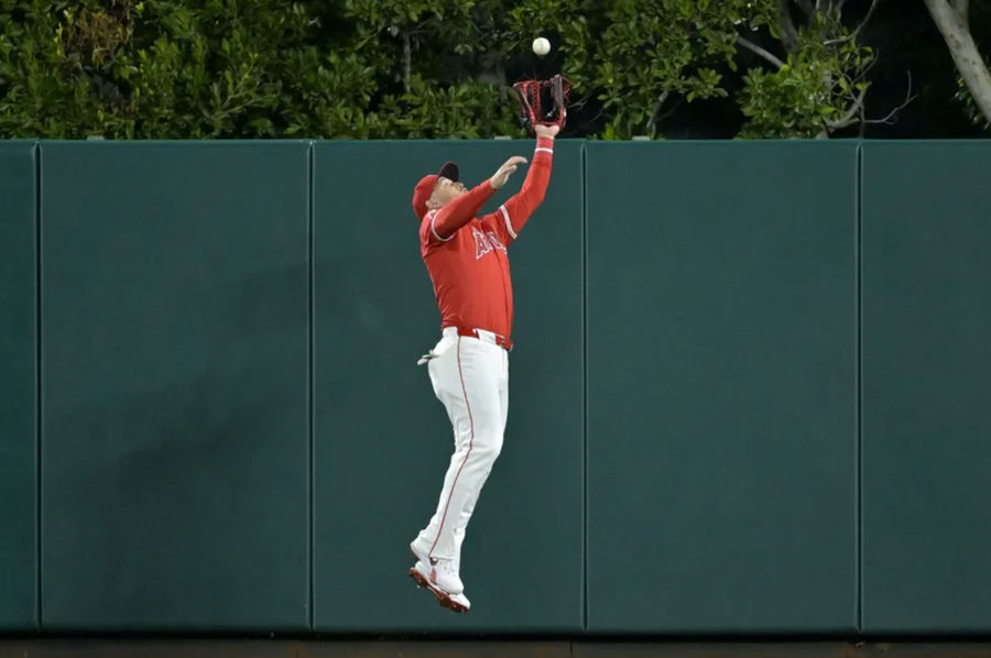 April 6, 2024; Anaheim, California, USA; Los Angeles Angels Outfielder Mike Trout (27) makes a jumping catch at the wall outside an airball hit by Boston Red Sox Outfielder Jarren Duran (16) in the eighth round of Angel Stadium. Mandatory Credit: Jayne Kamin-Oncea-Imagn Pictures