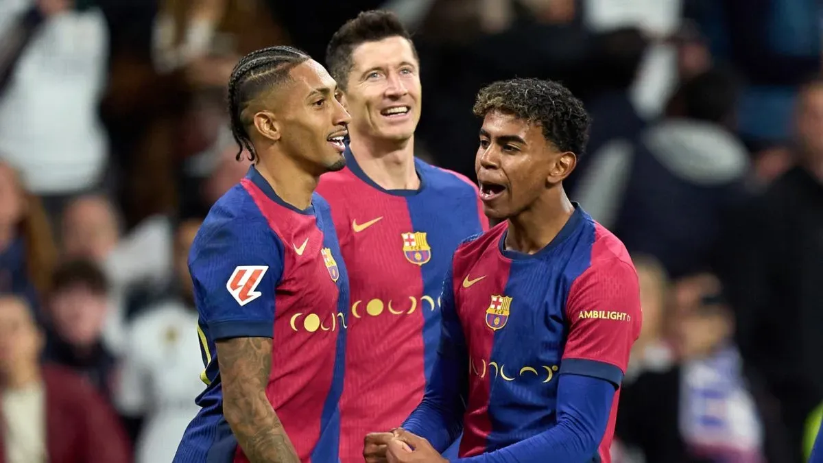 Raphinha from FC Barcelona celebrates and scored his team's fourth goal with teammates Robert Lewandowski and Lamine Yamal during the Laliga match between Real Madrid CF and FC Barcelona at Estadio Santiago Bernabeu on October 26, 2024 in Madrid, Spain.