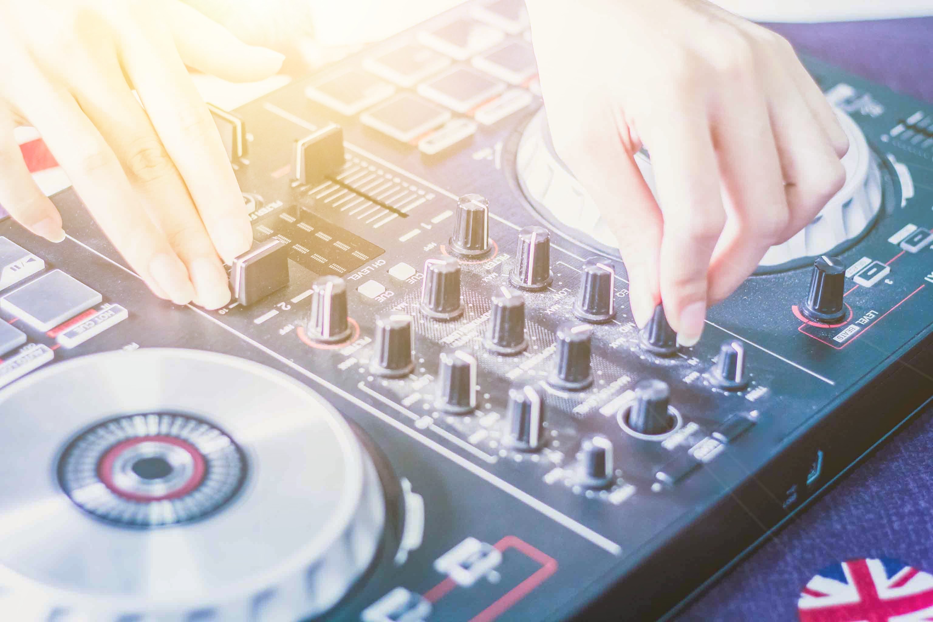 Image of a DJ mixing sound on a console